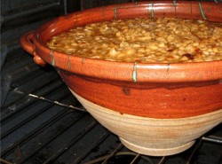 photo of a bright orange cassole in the oven with a cassolet inside