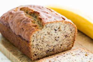 photo of a loaf of banana bread with a banana next to it