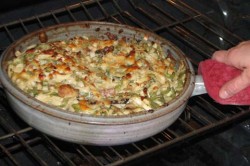 photo of bubbling cheesy food inside a cazuela in the oven