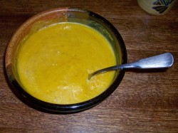 photo of pumpkin soup in a ceramic bowl with a spoon