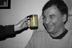 black and white photo of a man looking at a green ceramic mug