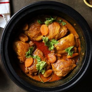 photo of chicken and vegetable tagine in a black bowl
