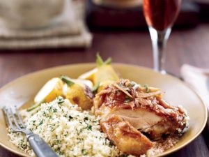 photo of chicken with couscous and potatoes on a yellow plate