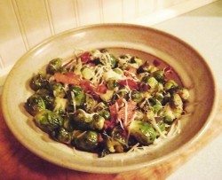 photo of brussel sprouts with bacon and cheese in a yellow bowl