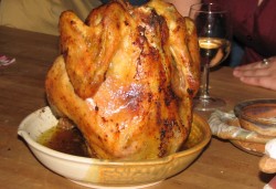 photo of a whole roasted chicken on a chicken baker