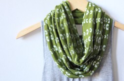 photo of a green and white scarf on a hanger with a grey tank top under it