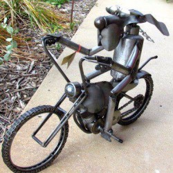 photo of a metal sculpture of a dog riding a motorcycle