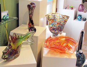 photo of wavy, mutlicolored blown glass bowls and sculptures