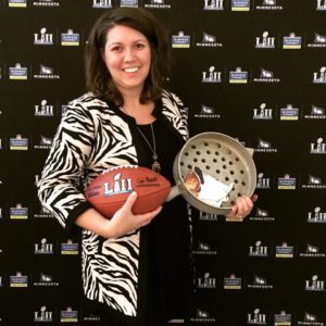 photo of a woman in a zebra print jacket holding a football and grill basket