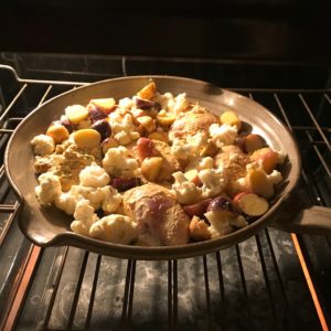 photo of skillet with chicken and wgetables in the oven