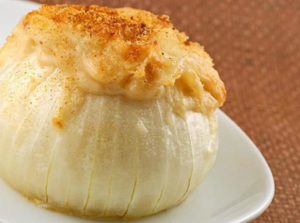 Photo of a baked onion with stuffing coming out of the top