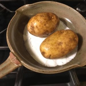 salt underneath potatoes in a skillet