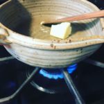 Butter melting in saucepan with wooden spoon