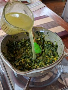 Adding broth to the saag paneer