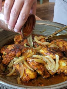 Morgan adding chicken broth to the tagine